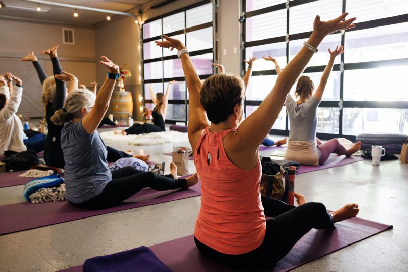 A small group class stretching together in a bright studio